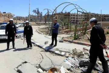 Photo prise le 16 avril 2018 de policiers syriens dans les rues de Douma, ville de la Ghouta orientale reprise par les forces du régime