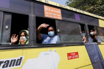 A bord d'un bus, des personnes libérées de la prison d'Insein à Rangoun (Birmanie) font le salut à trois doigts symbole de résistance, le 24 mars 2021