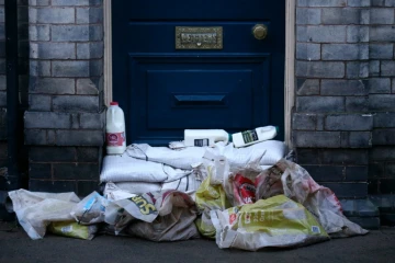 Des bouteilles de lait sont déposées au dessus de sacs de sable pour protéger l'entrée d'une maison des innondations à York, au nord de l'Angleterre, le 29 décembre 2015 