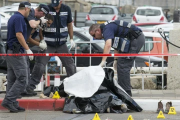 Les forces de sécurité israéliennes inspectent le corps d'un Palestinien abattu après avoir agressé au couteau une soldate israélienne et trois passants dans la ville côtière de Tel Aviv, en Israël, le 8 octobre 2015