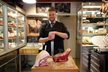 Le boucher Bastien Nicolas s'apprête à découper une côte de boeuf dans sa boucherie "Terroirs d'avenir", à Paris le 28 octobre 2015