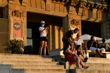 Des visiteurs assis devant le musée national d'art de Barcelone le 25 juillet 2020
