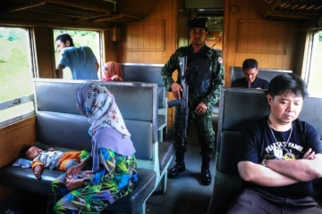 Un soldat au milieu des passagers du train de 12H33, le 21 novembre 2016 à Narathiwat dans l'extrême sud de la Thaïlande