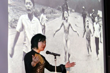 La Viétnamo-canadienne Phan Thi Kim Phuc devant une photo d'elle prise le 8 juin 1972 pendant la guerre du Vietnam à Nagoya, au Japon, le 13 avril 2016 