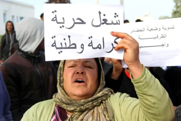 Une Tunisienne brandit une pancarte "Travail, liberté, dignité, nationalisme", pendant une manifestation à Kasserine, le 21 janvier 2016