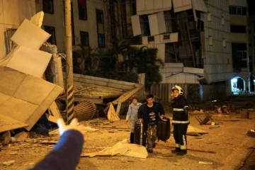 Deux personnes sont escortées par des sauveteurs depuis l'hôtel Marshal endommagé à Hualien, dans l'est de Taiwan, dans la nuit du 6 au 7 février 2018, après un violent séisme qui a frappé l'île
