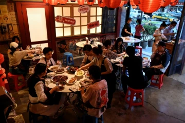 Des habitants dînent à la terrasse d'un restaurant, le 6 juin 2022 à Pékin