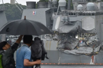 Un caméraman filme dans le port de Tokyo le 18 mai 2017 un destroyer américain entré en collision avec un cargo