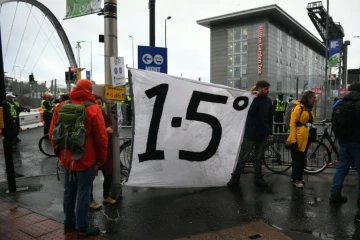 Des manifestants autour d'une banderole appelant à limiter le réchauffement de la planète à +1,5°, en marge de la COP26, à Glagow, en Ecosse