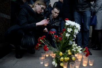 Des personnes déposent des fleurs et des bougies en mémoire aux victimes de l'attentat du métro, devant la station Sennaya, le 3 avril 2017 à Saint-Pétersbourg