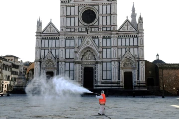 Une employé municipal désinfecte la place Santa Croce à Florence, le 21 mars 2020