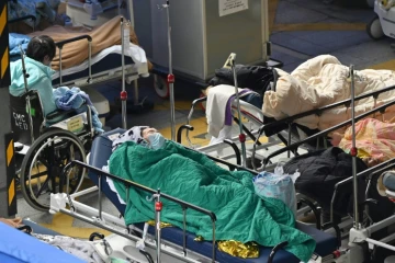 Des malades allongés devant le centre médical Caritas à Hong Kong, le 18 février 2022