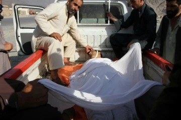 Des hommes transportent un autre homme tué dans un attentat dans l'est de l'Afghanistan, le 11 septembre 2018