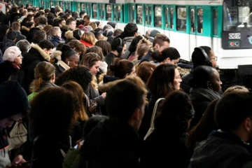 Des personnes attendent sur un quai de métro pendant une grève contre la réforme des retraites, en janvier 2020 à la gare Saint-Lazare à Paris