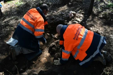 Deux archéologues fouillent le sol d'un terrain millitaire à la recherche de sépultures d'enfants harkis, le 28 février 2022 à Laudun-l'Ardoise, dans le Gard