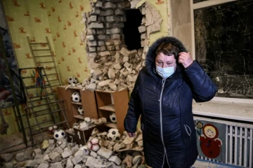 Une femme se tient parmi les décombres dans une école maternelle touchée par des obus séparatistes, à Stanitsa Louganska en Ukraine le 17 février 2022