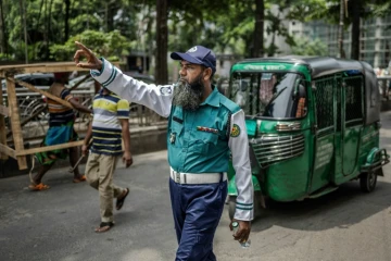 Un policier régule la circulation à Dacca, le 12 août 2024 au Bangladesh