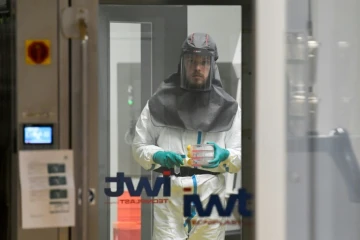 Un virologue travaillant à la recherche d?un traitement contre le coronavirus, détient des échantillons dans un laboratoire de niveau 3 à l?Institut Rega de recherche médicale de l?Université de Louvain, le 28 février 2020 en Belgique