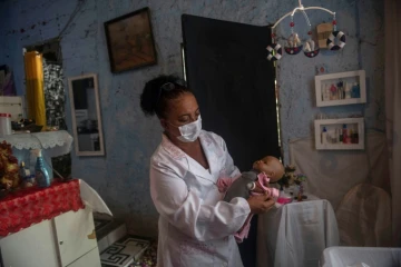 Suelen da Silva ausculte sa patiente, une poupée; qu'elle va restaurer, chez elle dans son "hopital de poupées" à Niteroi, près de Rio de Janeiro, le 10 décembre 2020