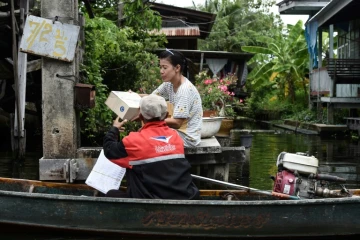 Nopadol, postier, distribue des lettres et colis aux habitants vivant sur les bords d'un canal dans la province de Bang Khun Thian, près de Bangkok en Thaïlande, le 17 juillet 2017