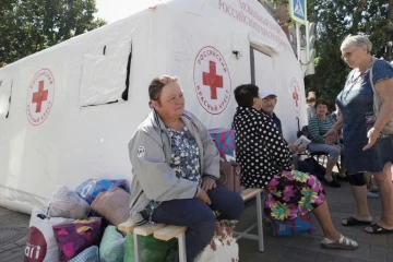 Des personnes déplacées par les combats reçoivent une aide humanitaire au point de distribution de la Croix-Rouge russe à Koursk, le 15 août 2024