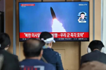 Des personnes devant un écran de télévision montrant des images d'archive d'un essai de missile nord-coréen, dans une gare de Séoul, en Corée du Sud, le 22 avril 2024