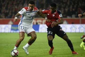 L'attaquant néerlandais de Lyon Memphis Depay (g) à la lutte avec le défenseur ivoirien de Lille Yves Dabila le 1er décembre 2018 à Villeneuve-d'Ascq