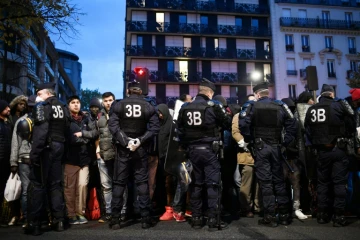 Des policiers entourent des migrants pendant l'évacuation du camp installé entre les stations de métro Stalingrad et Jaurès à Paris le 4 novembre 2016