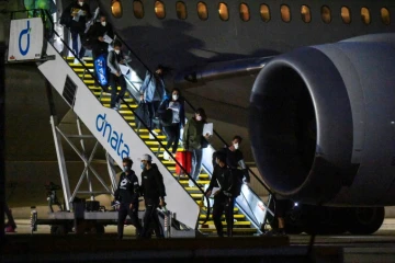 Joueurs de tennis et officiels descendent de leur avion à l'aéroport de Melbourne, le 14 janvier 2021