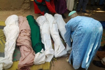Un habitant enveloppe des cadavres avec des linceuils après une attaque de bandits dans la province de Zamfara au Nigéria, le 18 juin 2013