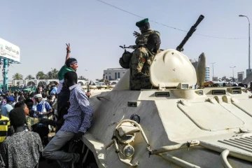 Des manifestants soudanais saluent un véhicule blindé de l'armée lors d'une manifestation devant son QG à Khartoum, le 9 avril 2019