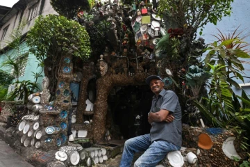 L'artiste Estevao Silva da Conceicao devant sa maison de la favela Paraisopolis à Sao Paulo, le 11 octobre 2024 au Brésil