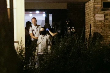 Une femme, la tête recouverte d'une couverture, est emmenée   par les policiers le 8 septembre 2016 à Boussy-Saint-Antoine 
