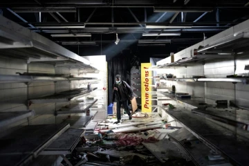 Un homme parcourt es rayons d'un supermarché pillé et incendié, à Dakar, le 6 mars 2021.