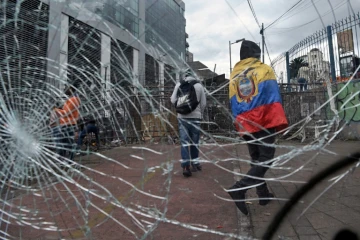 Un manifestant indigène enveloppé d'un drapeau équatorien près d'une barricade au voisinage de l'Assemblée nationale, à Quito le 26 juin 2022
