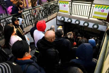Des voyageurs attendent que les grilles du métro s'ouvrent le 20 décembre 2019 à la station Porte d'Orléans à Paris