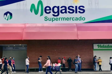 Des clients font la queue devant le supermarché Megasis à Caracas le 31 juillet 2020