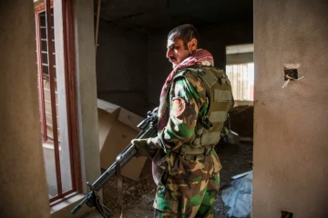 Un combattant peshmerga surveille des positions hostiles dans un immeuble de Bashiqa, le 9 novembre 2016 en Irak