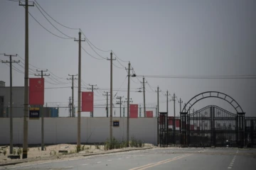 Des drapeaux chinois le long d'une route menant à un centre de rééducation politique où seraient détenus des musulmans ouïghours, le 31 mai 2019 près de Hotan, dans le Xinjiang