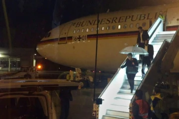 La chancelière allemande Angela Merkel descend de son avion le 29 novembre 2018 au soir à l'aéroport de Cologne après un atterrissage d'urgence