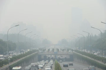 Des véhicules lors d'un jour de brouillard à Pékin, le 23 juin 2015