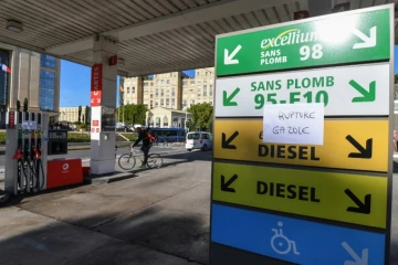 Un cycliste passe à côté d'une station essence à Montpellier le 4 décembre 2018