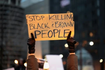Un manifestant à Chicago le 2 avril 2018, proteste contre les meurtres de Noirs par la police américaine  