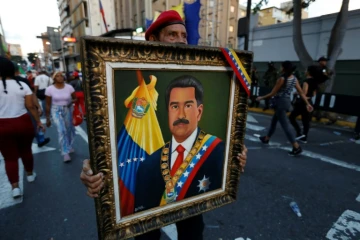 Un partisan du président vénézuélien Nicolas Maduro tient son portrait lors d'une marche de soutien à Caracas le 17 août 2024