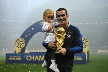 L'attaquant français Antoine Griezmann pose avec sa fille et la Coupe du monde, à l'issue de la finale le 15 juillet 2018 à Moscou