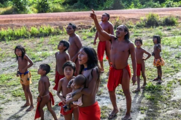 Des Indiens Waiapi regardent un avion survoler leur village de Manilha, au coeur de la forêt amazonienne, le 15 octobre 2017