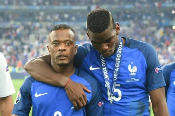 Patrice Evra (g) et Paul Pogba (d) quittent la pelouse du Stade de France dépités après la défaite des Bleus face au Portugal en finale de l'Euro-2016