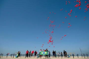 Lâcher de ballons sur la plage de Copacabana de Rio en hommage aux plus de 100.000 morts du Covid-19 au Brésil, le 8 août 2020