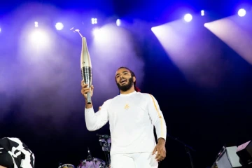 Le judoka français handisport Helios Latchoumanaya porte la flamme des  Jeux paralympiques à Saint-Cloud, dans la banlieue de Paris le 25 août 2024