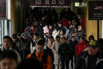 Des voyageurs débarquent d'un ferry, le 22 décembre 2024 dans la ville chinoise de Wuhan, dans la province centrale du Hubei 